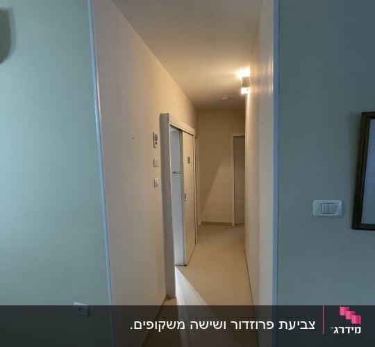 מסדרון עם דלתות ותאורה על הקיר